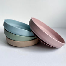 Load image into Gallery viewer, three silicon suction plates in baby blue, sage & latte colour stacked with a rose silicone suction plate leaning on them