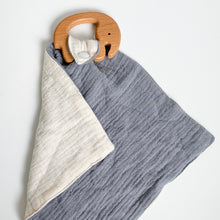 Load image into Gallery viewer, a wooden elephant teether attached to a steel blue muslin comforter folded showing white underside