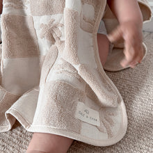 Load image into Gallery viewer, Close up of the hooded terry beach towel showing Calf & Crew logo patch