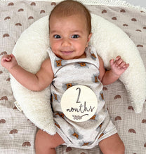Load image into Gallery viewer, a baby lying on a white boucle moon feeding pillow with a "2 months" milestone wooden disc resting on them