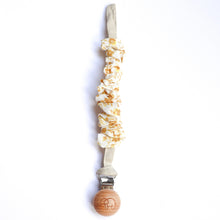 Load image into Gallery viewer, a cotton scrunch dummy clip in golden colour with the elephant logo on the wooden clip