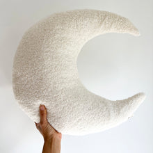 Load image into Gallery viewer, a hand holding up a white boucle moon feeding pillow
