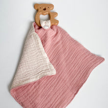 Load image into Gallery viewer, a wooden koala teether attached to a coral pink muslin comforter folded showing white underside