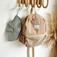 Load image into Gallery viewer, a everyday sunhat in cloudy blue hanging on a wooden hook with a sand coloured corduroy backpack