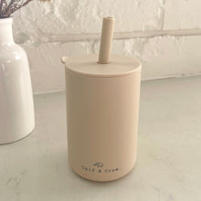 Load image into Gallery viewer, the silicone sippy cup in sand colour showing the calf & crew logo on the bottom of the cup