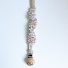 Load image into Gallery viewer, a cotton scrunch dummy clip in gingham colour with the elephant logo on the wooden clip