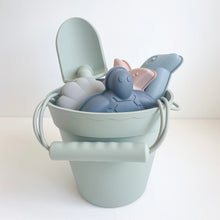 Load image into Gallery viewer, the silicone beach toy set in palm breeze colour showing the silicone shape moulds and spade inside the bucket