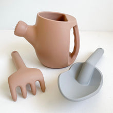 Load image into Gallery viewer, Peony silicone garden set showing peach watering can and rake and a grey spade