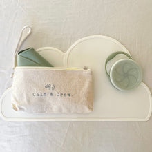Load image into Gallery viewer, Sage bib foled in a beige pouch with Calf & Crew logo, with a sage snack cup on a white placemat