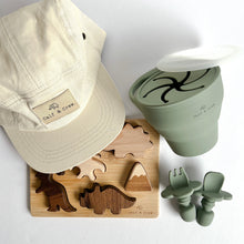 Load image into Gallery viewer, The crew cap in cream with the wooden dinosaur puzzle, and a collapsible snack cup and easy grip spoon and fork in sage colour