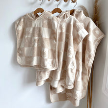 Load image into Gallery viewer, the three sizes of the hooded terry beach towel on wooden hangers