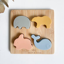 Load image into Gallery viewer, top view of silicone animal puzzle showing wooden base with a silicone elephant, bear, bunny and whale