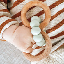 Load image into Gallery viewer, a baby's hand holding the wooden silicone ring teether in mint colour
