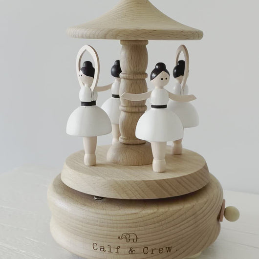 a wooden musical carousel with four dancing ballerinas spinning and playing music