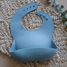 Load image into Gallery viewer, baby blue silicone catcher bib on a tan rug
