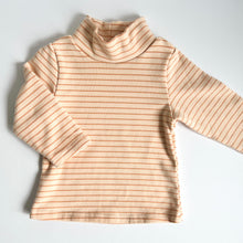 Load image into Gallery viewer, the peach stripped thick long sleeve skivvy top with one arm folded across the body
