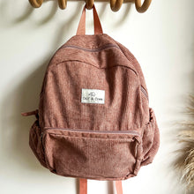 Load image into Gallery viewer, a dusty rose corduroy backpack hanging on a wooden hook
