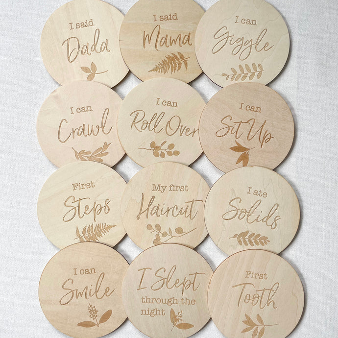 12 wooden discs engraved with different milestones