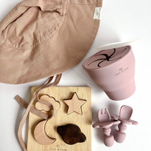 Load image into Gallery viewer, the floppy sun hat in rose colour with the wooden night sky puzzle, and a collapsible snack cup and easy grip spoon and fork in rose colour
