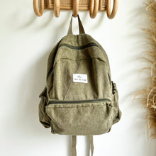Load image into Gallery viewer, khaki coloured corduroy backpack hanging on wooden hooks
