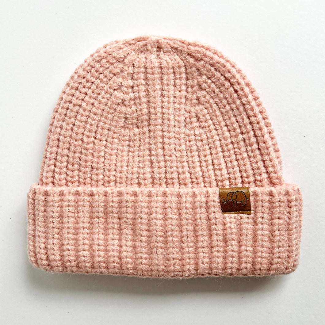 a chunky knit toddler beanie in blush colour with a leather calf & crew logo