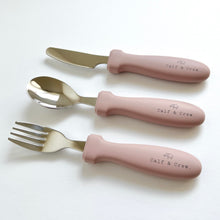 Load image into Gallery viewer, the stainless steel kids cutlery set showing a fork, spoon and knife in rose silicone with the calf &amp; crew logo
