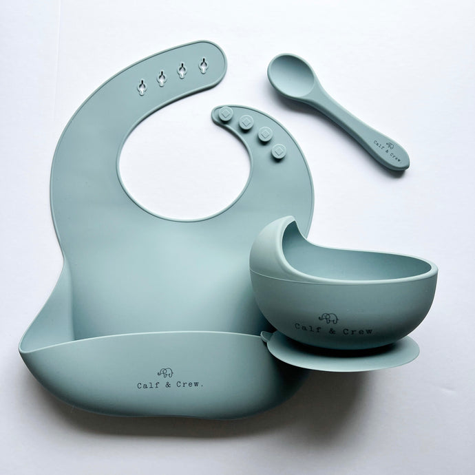Silicone bib, silicone suction bowl, and silicone spoon in baby blue colour all with the Calf & Crew logo