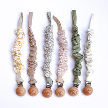 Load image into Gallery viewer, six cotton scrunch dummy clips in golden, dottie latte, ivy, gingham, dottie sage, and palm leaf
