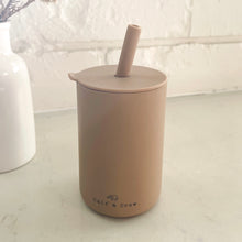 Load image into Gallery viewer, the silicone sippy cup in latte colour showing the calf &amp; crew logo on the bottom of the cup

