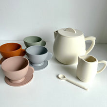 Load image into Gallery viewer, the silicone toy tea set in snow colour showing 4 different coloured tea cups &amp; saucers, and a white milk jug, stirring spoon, and teapot
