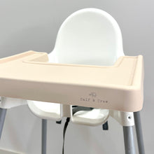 Load image into Gallery viewer, a nude silicone high chair table cover on a white ikea highchair highlighting the Calf &amp; Crew logo
