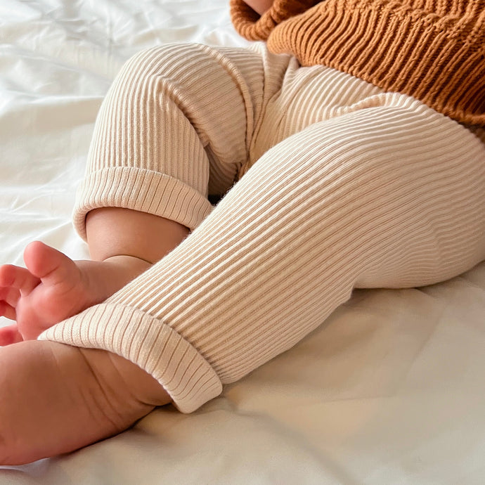 a baby's legs showing  the ribbed straight fit leggings in beige