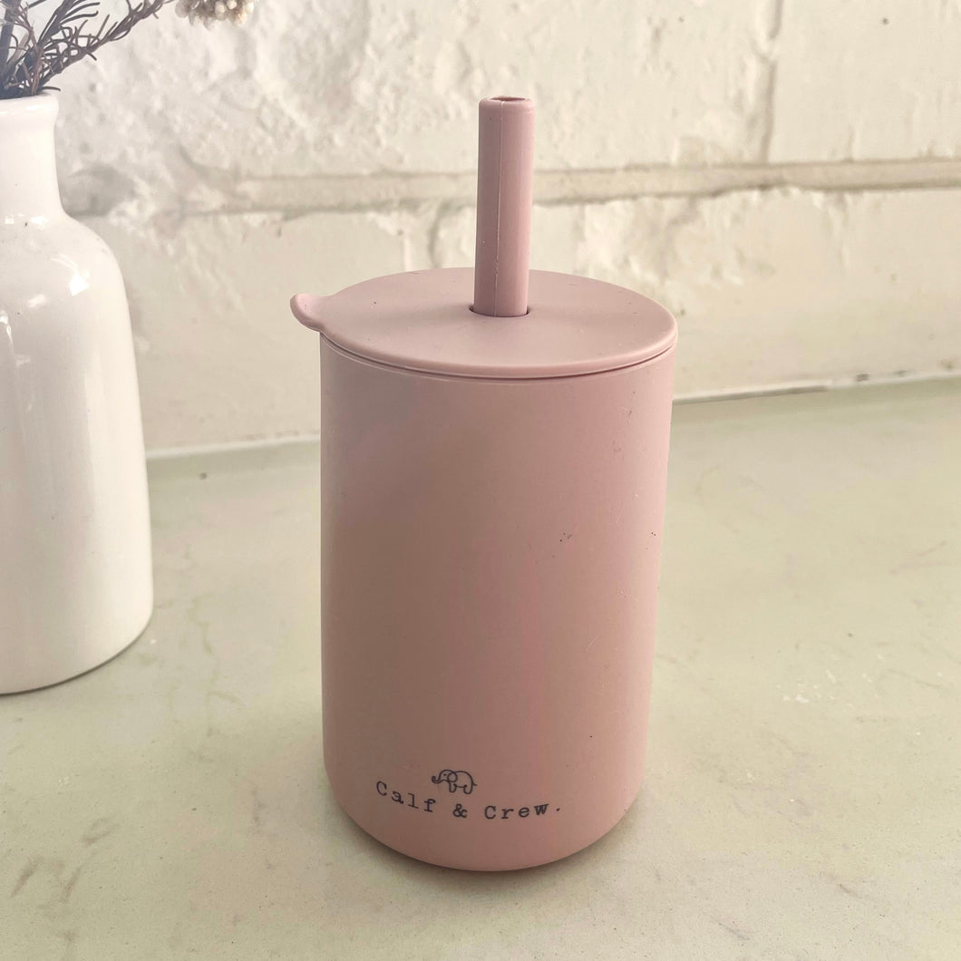 the silicone sippy cup in rose colour showing the calf & crew logo on the bottom of the cup
