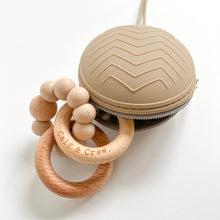 Load image into Gallery viewer, the soother case in latte colour open with a wooden silicone ring teether coming out of it
