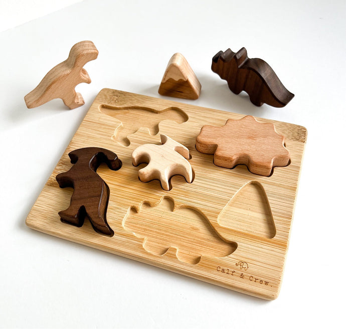 the wooden dinosaur puzzle with some pieces standing up near the base