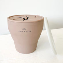 Load image into Gallery viewer, expanded collapsible snack cup with Calf &amp; Crew logo in latte, with a white lid leaning against it
