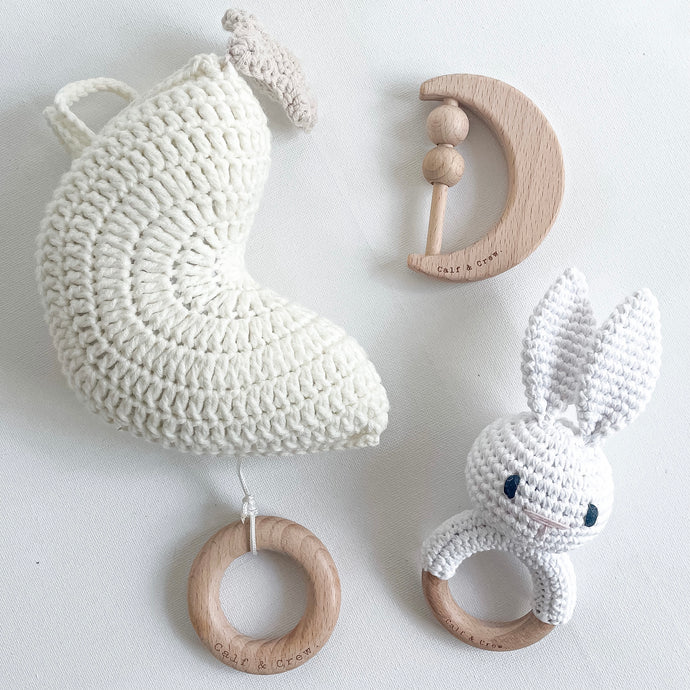 the crochet moon musical pull toy in ivory with wooden moon rattle and a white crochet bunny rattle