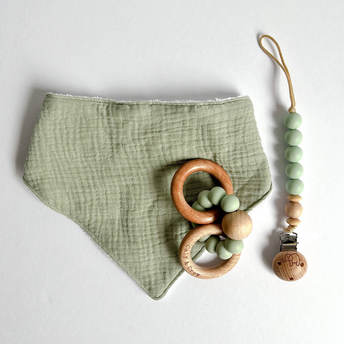 Sage muslin bib with a wooden silicone ring teether and silicone dummy clip in mint
