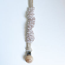 Load image into Gallery viewer, a cotton scrunch dummy clip in gingham colour with the elephant logo on the wooden clip
