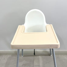 Load image into Gallery viewer, a nude silicone high chair table cover on a white ikea highchair
