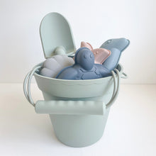 Load image into Gallery viewer, the silicone beach toy set in palm breeze colour  showing the silicone shape moulds and spade inside the bucket
