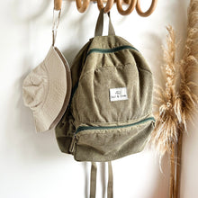 Load image into Gallery viewer, a everyday sunhat in sand hanging on a wooden hook with a khaki coloured corduroy backpack
