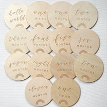 Load image into Gallery viewer, 14 wooden discs with different monthly milestones and a rainbow engraved on them
