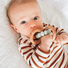 Load image into Gallery viewer, a baby laying down chewing on the wooden silicone ring teether in mint colour
