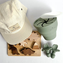 Load image into Gallery viewer, The crew cap in cream with the wooden dinosaur puzzle, and a collapsible snack cup and easy grip spoon and fork in sage colour
