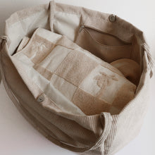 Load image into Gallery viewer, tan bag opened with checkered beige and tan beach towl inside
