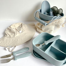 Load image into Gallery viewer, the everyday sun hat in cream with the silicone beach toy set in ocean, an opened silicone bento lunchbox in baby blue with a stainless steel spoon, fork and knife in baby blue colour 
