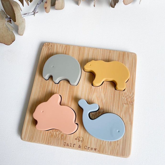 silicone animal puzzle showing wooden base with a silicone elephant, bear, bunny and whale