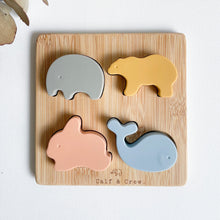 Load image into Gallery viewer, top view of silicone animal puzzle showing wooden base with a silicone elephant, bear, bunny and whale
