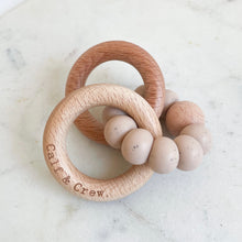 Load image into Gallery viewer, a wooden teether with a chai silicone ring and the calf &amp; crew logo engraved on it
